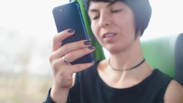 Chica utiliza un teléfono inteligente en un autobús de transporte público . — Vídeos de Stock