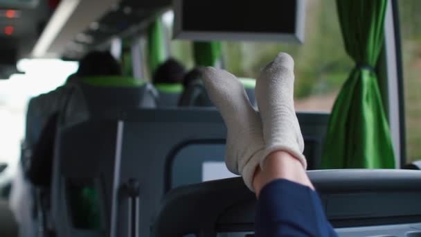 Närbild av benen på en flicka som sitter på en turistbuss. — Stockvideo