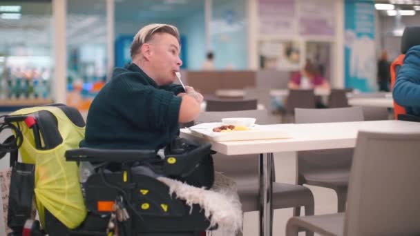 Behinderte Frau, die an einem Tisch im Esszimmer sitzt, isst Essen. — Stockvideo