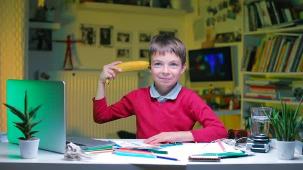 The child sitting at the table put the ban to his head — Stock Video