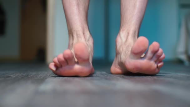 Close-up van mannelijke voeten die op de vloer staan. — Stockvideo