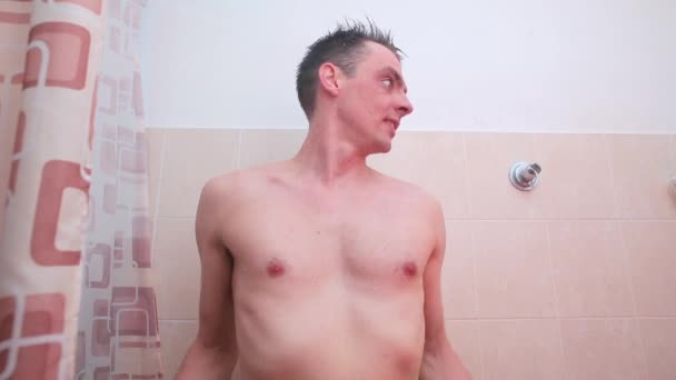 Egy jókedvű férfi letöröl egy törölközőt a fürdőszobában zuhanyozás után. — Stock videók