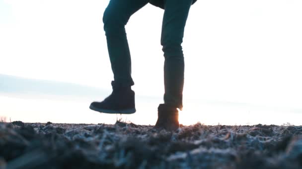 Pies de un viajero caminando sobre el suelo sobre el fondo del sol . — Vídeos de Stock