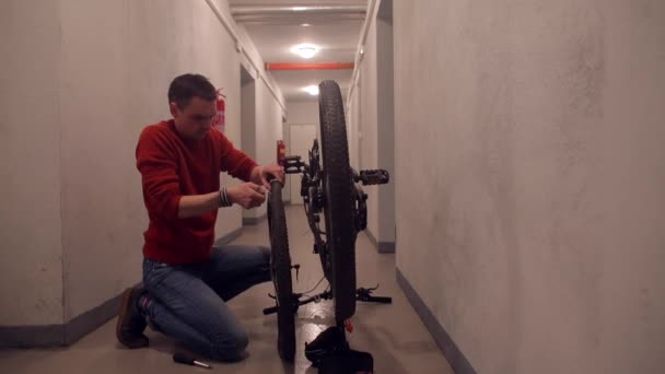 A man is repairing a bicycle wheel. — Stock Video