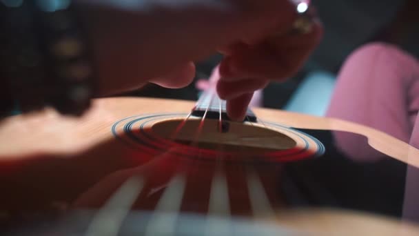 De muzikant speelt de snaren van een gitaar tijdens een concert. — Stockvideo