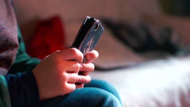 Nahaufnahme eines Smartphones in einer Hülle in den Händen eines kleinen Mädchens. — Stockvideo