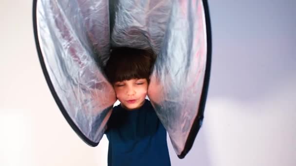 Retrato de un niño alegre jugando con un reflector . — Vídeos de Stock