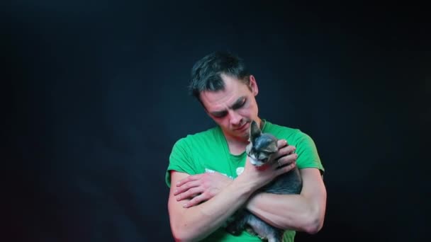 Funny animal trainer with a cat in his arms posing. — Stock Video