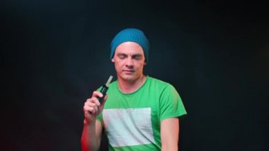 Müzisyen gözlük takar ve bir buharlaştırıcı ile marihuana içmeye başlar.. 