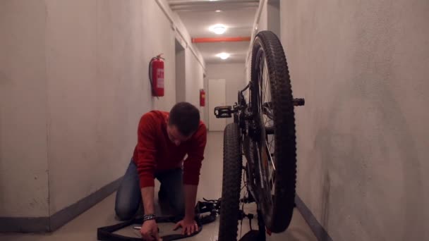 Un hombre está reparando una rueda en una bicicleta . — Vídeos de Stock