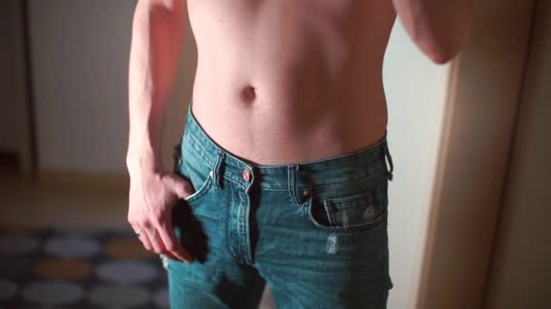 A man with a naked torso takes a lighter out of his pocket and lights it. — Stock Video