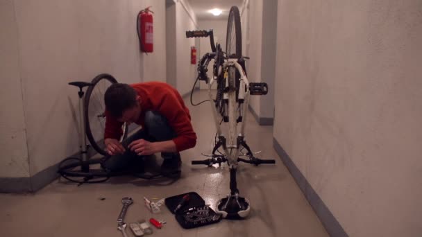 机械师把自行车轮子插在车库里. — 图库视频影像