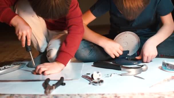 Twee schoolkinderen spelen met een bouwvakker op de grond op school. — Stockvideo