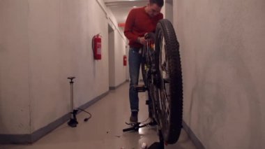 Bir adam bisiklete mühürlü tekerlek takar.