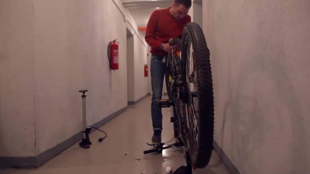 Un hombre pone una rueda sellada en una bicicleta — Vídeos de Stock