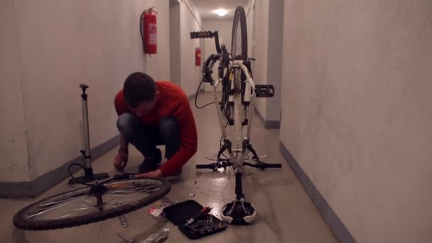 Un mecánico monta una rueda de bicicleta antes de instalarla en un garaje . — Vídeos de Stock