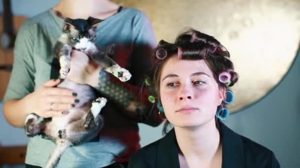 Portrait of a young beautiful girl with curlers on her hair. — Stock Video