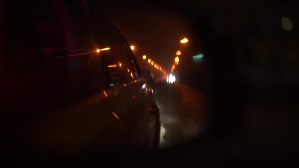 Vista do espelho retrovisor em um carro à noite . — Vídeo de Stock
