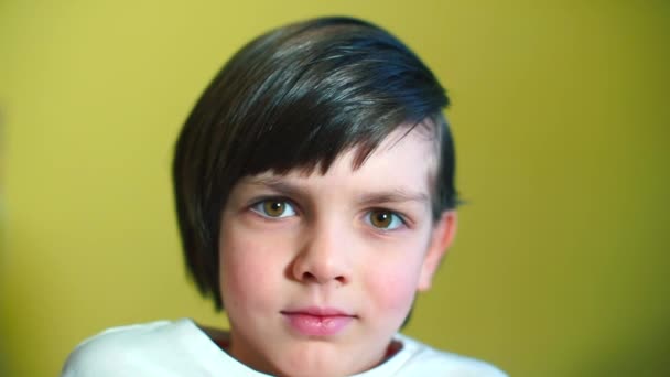 Retrato de un niño sobre un fondo amarillo . — Vídeo de stock
