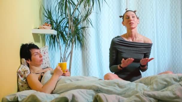 Dvě feministky mluví v posteli v pokoji. — Stock video