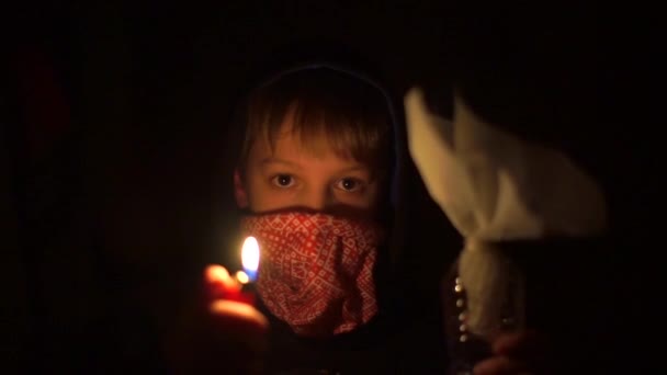 A masked football fan holds fire and incendiary mixture in front of him. — Stock Video