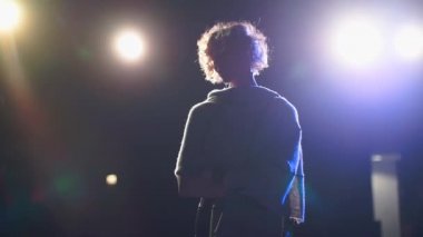 The silhouette of the singer on the stage of the concert hall.