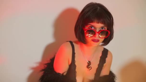 Menina bonita em óculos vermelhos em uma festa excêntrica . — Vídeo de Stock
