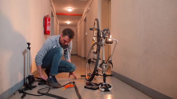 Een video blogger maakt een video en repareert een fietswiel in een garage — Stockvideo