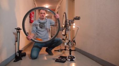 Bir tamirci kırık bir bisiklet tekerleğini kontrol eder..