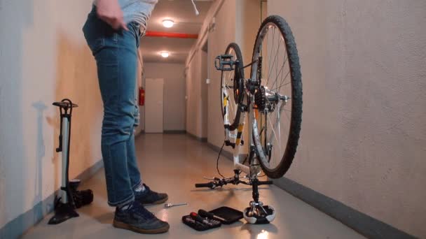 Un mecánico inspecciona una bicicleta en un taller. — Vídeos de Stock