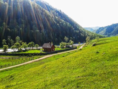 Güneşle kutsanmış bir dağ vadisinde nehir kıyısında bir ev..