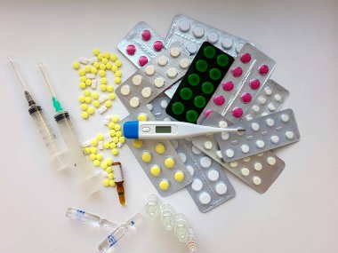 Eczacılık firması. Antibiyotikler, çeşitli haplar, şırıngalar, beyaz arka planda ampuller..