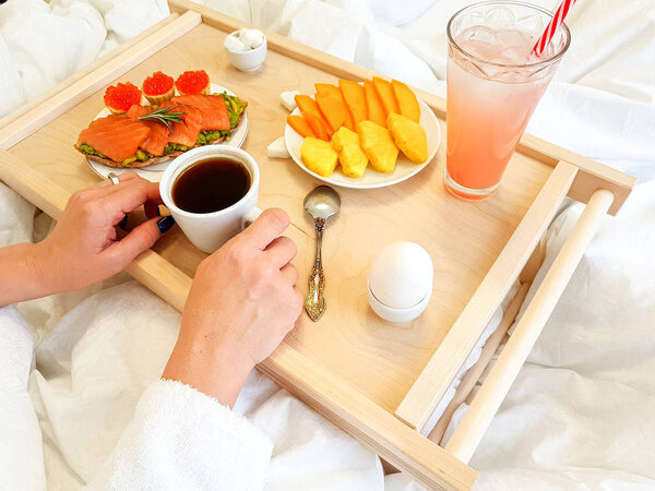 Healthy breakfast in bed for a girl in a cozy bedroom.