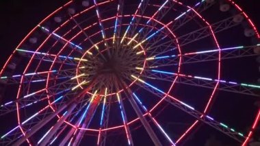 Hareket eden bir dönme dolap gece farklı renklerde parlar..