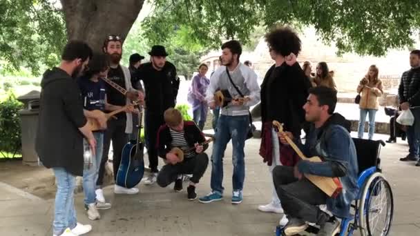Skupina pouličních hudebníků hraje na hudební nástroje a zpívá písně. — Stock video