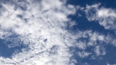 Kümülüs bulutları açık mavi gökyüzünde. Zaman Ayarı 4k videosu.