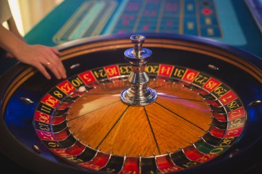 Krupiye ve zengin zengin insanlar kumar bir grup el ile çok renkli casino rulet hareket, tabloyla bir yakın çekim canlı görüntü 