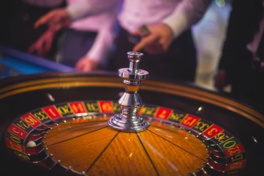 Krupiye ve zengin zengin insanlar kumar bir grup el ile çok renkli casino rulet hareket, tabloyla bir yakın çekim canlı görüntü 