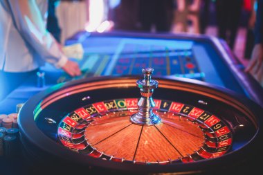 Krupiye ve zengin zengin insanlar kumar bir grup el ile çok renkli casino rulet hareket, tabloyla bir yakın çekim canlı görüntü 