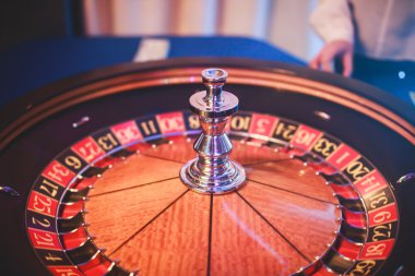 Krupiye ve zengin zengin insanlar kumar bir grup el ile çok renkli casino rulet hareket, tabloyla bir yakın çekim canlı görüntü 