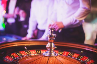 Krupiye ve zengin zengin insanlar kumar bir grup el ile çok renkli casino rulet hareket, tabloyla bir yakın çekim canlı görüntü 