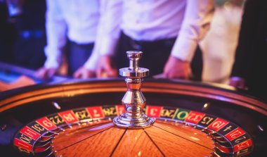 Krupiye ve zengin zengin insanlar kumar bir grup el ile çok renkli casino rulet hareket, tabloyla bir yakın çekim canlı görüntü 