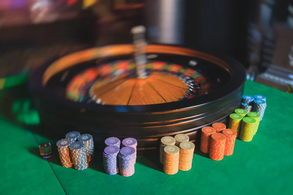 Ein lebendiges Bild aus nächster Nähe von einem bunten Casino-Tisch mit Roulette in Bewegung, mit der Hand eines Croupier und einer Gruppe reicher Glücksspieler — Stockfoto