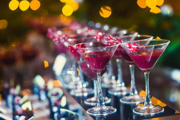 Красивая линия рядов из различных цветных алкогольных коктейлей с мятой на открытом воздухе партии, мартини, водки с пузырьками, и другие на украшенный букет питания свадебный стол на открытом воздухе событие, в почти — стоковое фото