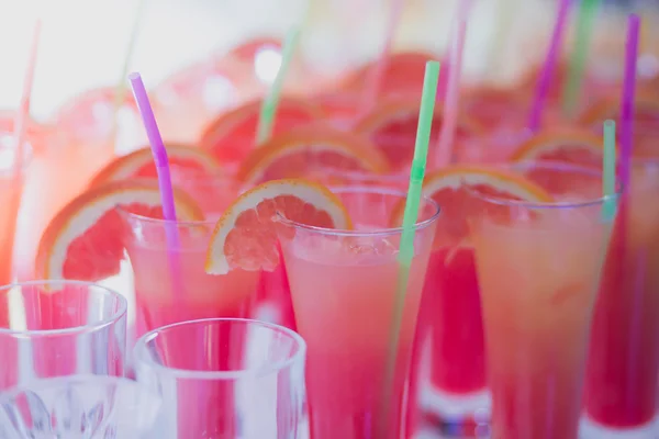Beautiful row line of different colored alcohol cocktails with mint on a open air party, martini, vodka with bubbles,and others on decorated catering bouquet wedding table on open air event, in nigh — Stock Photo, Image