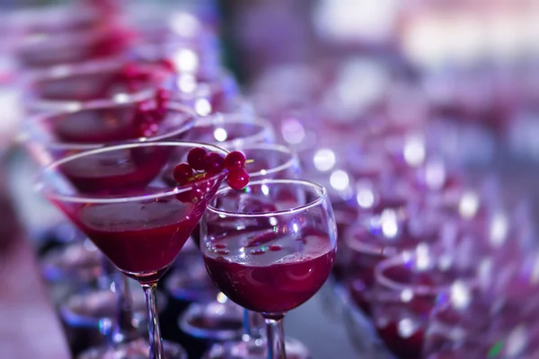 Hermosa línea de fila de cócteles de alcohol de diferentes colores con menta en una fiesta al aire libre, martini, vodka con burbujas, y otros en la mesa de bodas ramo de catering decorado en el evento al aire libre, en cerca — Foto de Stock