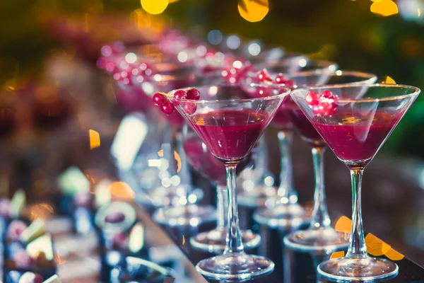 Hermosa línea de fila de cócteles de alcohol de diferentes colores con menta en una fiesta al aire libre, martini, vodka con burbujas, y otros en la mesa de bodas ramo de catering decorado en el evento al aire libre, en cerca —  Fotos de Stock