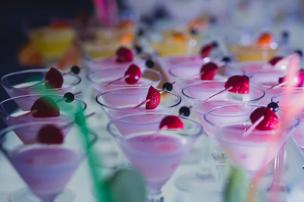 Vackra raden av olika färgade Cocktailar med mint på ett öppet luftar parti, martini, vodka med bubblor och andra på inredda med självhushåll bukett bröllop tabellen på utomhus händelse, i nära — Stockfoto