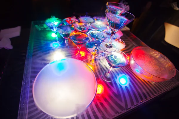 Hermosa línea de fila de cócteles de alcohol de diferentes colores con menta en una fiesta al aire libre, martini, vodka con burbujas, y otros en la mesa de bodas ramo de catering decorado en el evento al aire libre —  Fotos de Stock