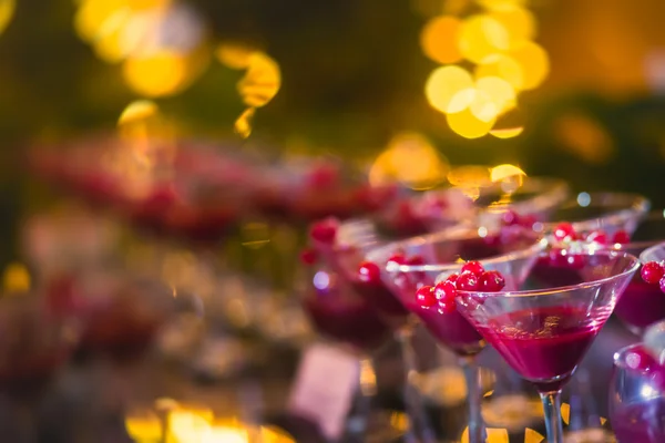 Hermosa línea de fila de cócteles de alcohol de diferentes colores con menta en una fiesta al aire libre, martini, vodka con burbujas, y otros en la mesa de bodas ramo de catering decorado en el evento al aire libre —  Fotos de Stock